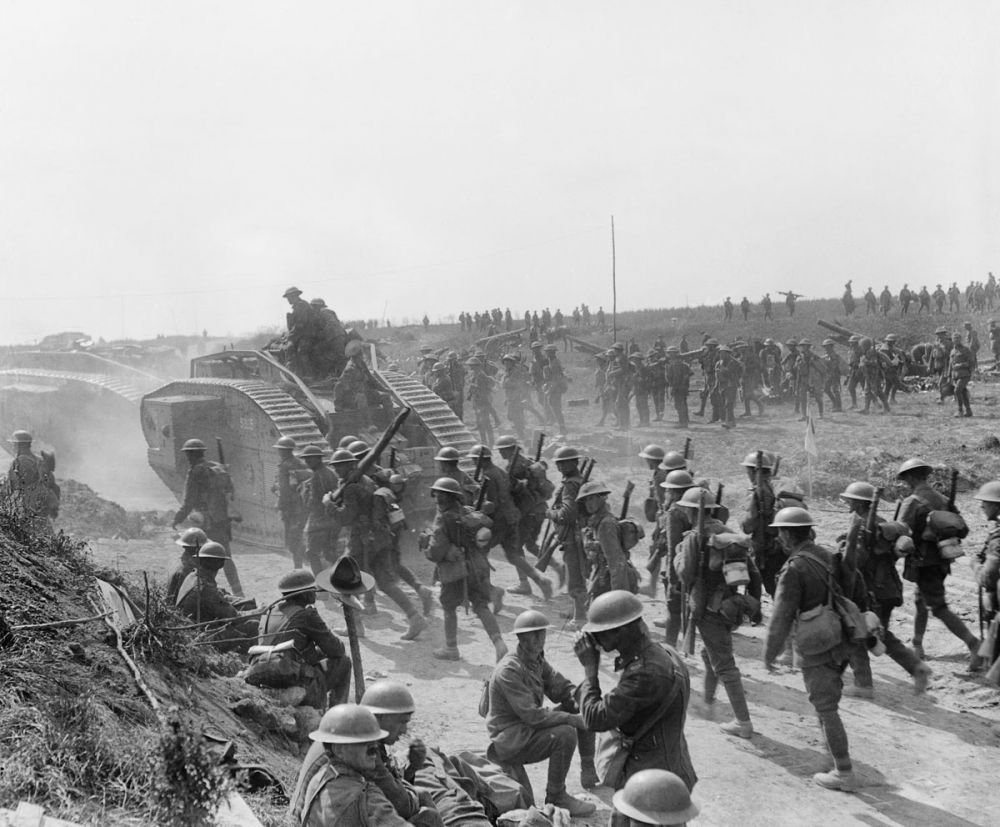 Infantry advancing, some riding on tanks, after the capture of Grévillers by British and New Zealand soldiers, 25 August 1918.